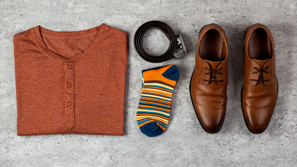 Flat lay composition of male elegant leather shoes; shirt and other accessories on concrete background