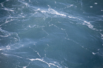 Background of a texture of a water, sea water illuminated by sunlight.