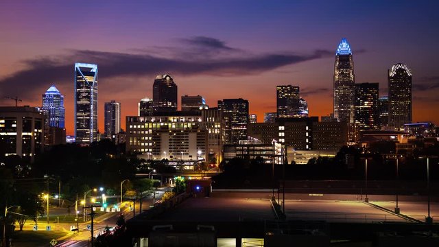 Charlotte NC Generic Vibrant Night Cityscape Timelapse at Sunset with Moving Traffic and Lights on Skyscraper Buildings on the Horizon with a Colorful Sky during Dusk in North Carolina
