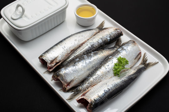 Fresh washed and scaled fish without heads on white plate