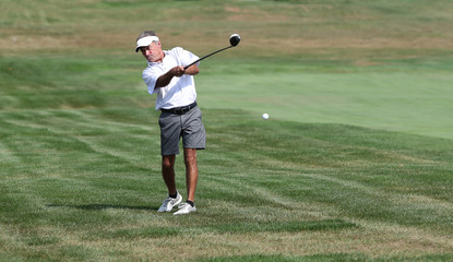 A golfer hits a shot competing in a tournament