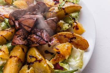 Baked potatoes with boiled chicken liver on a plate
