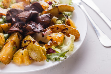 Baked potatoes with boiled chicken liver on a plate