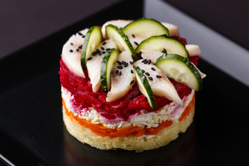Russian salad herring under fur coat on a dark background