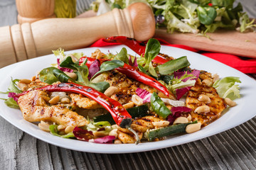 Mexican salad with hot pepper chiken fillet lettuce on plate