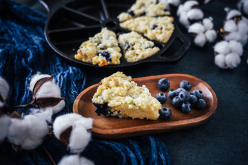 close up of one blueberry scone, dark background
