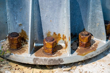 Steel bolts and rusty steel nut on gray steel plate of lamp post. Structural Detail of a lighting...