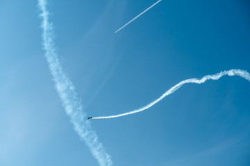 Traces of airplanes in the sky. Elements of aerobatics on a sports plane.