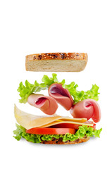 Sandwich with whole grain bread, salad, cheese, tomato and ham on a white isolated background
