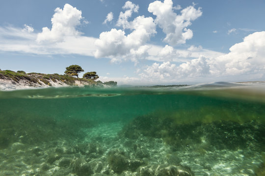 Picturesque view of rocky island and sea bottom on sunny summer day in Halkidiki, Greece