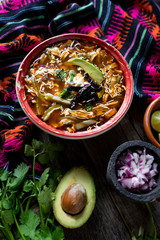 Mexican tortilla soup on colorful background