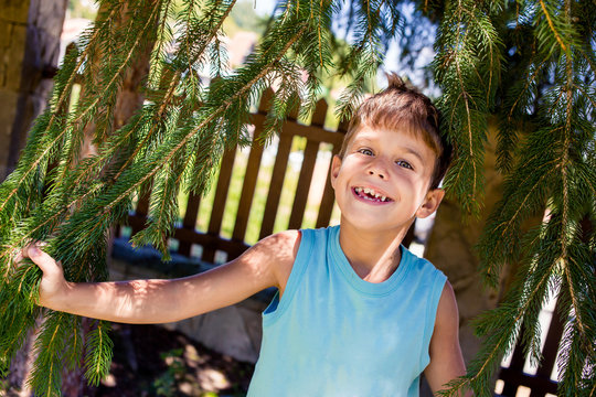 Portrait of little boy in blue t-shirt with green eyes and croocked teeth.
