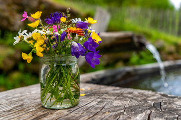 Strauß aus wilden Blumen und Kräutern an einem Brunnen