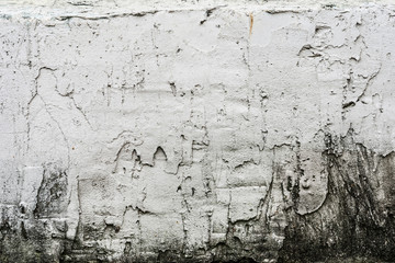 texture of an old wall with uneven cracked stucco, dirty surface of the exterior painted wall