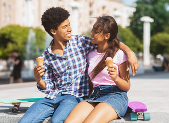 Happy couple eating ice cream in the street