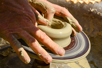 Craftsman artist making craft, pottery, sculptor from fresh wet clay on pottery wheel, selected...