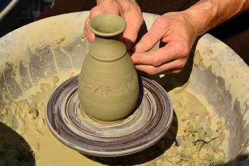 Craftsman artist making craft, pottery, sculptor from fresh wet clay on pottery wheel, selected focus