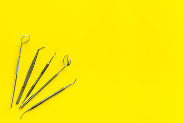 dentist instruments on yellow doctor's office desk background top view mock-up