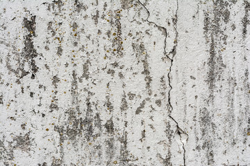 texture of an old wall with uneven cracked stucco, dirty surface of the exterior painted wall