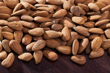 Obraz premium Roasted almonds on dark wood surface