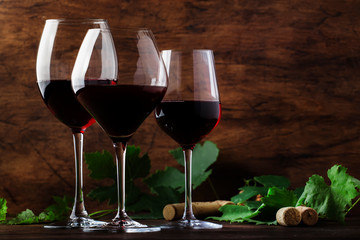 Selection of red wine on wine tasting. Dry, semi-dry, sweet red wines in special wine glasses on old wooden table background. Copy space