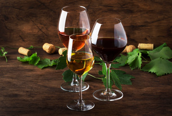 Wine set. Red, white and rose wine in assortment in wineglasses. Wine tasting, vintage wooden...
