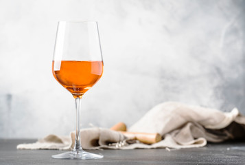 Orange wine in big wine glass, fashionable modern drink, gray counter background, copy space, selective focus