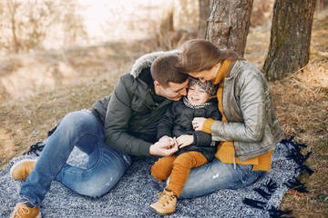 Family with cute little son. Mother in a yellow sweater. Parents with child in a spring park