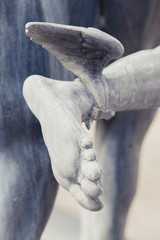 Close up fragment of ancient statue of the antique god of commerce, merchants and travelers Hermes (Mercury). He is olympic gods messenger with wings on his feet