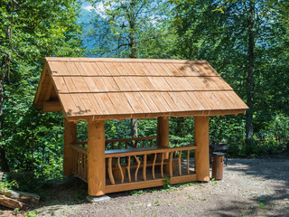 Beautiful summer house from a log of a large tree with barbecue for barbecue in forest