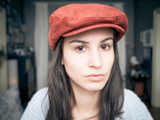 Portrait of beautiful young woman wearing red hat 