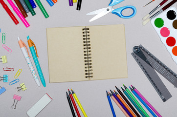 Back to school concept. Notebook, paint, pencils and scissors. School accessories.
