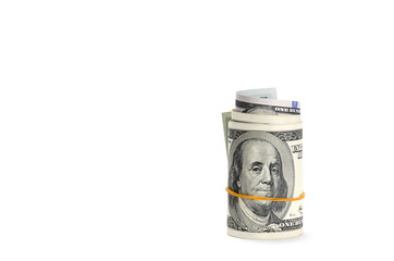 American dollars are twisted into a roll and tied with an elastic band, isolated on a white background.  