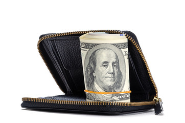 Twisted dollar bills lie in a black wallet isolated on a white background.
