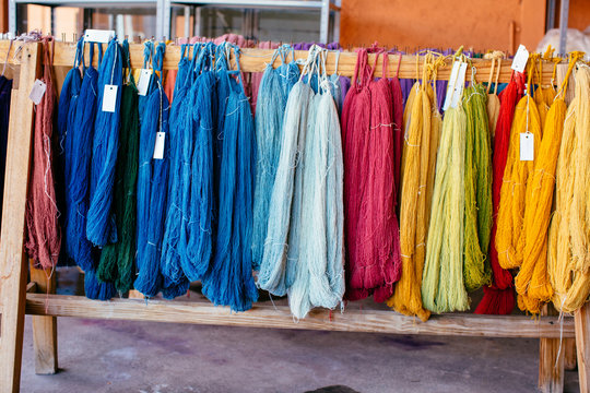 Multicolor woolen thread arranged on wooden block