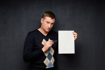 Portrait of serious man holding blank paper sheet