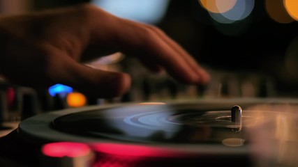 Amazing Close Up of DJ Hands Mixing and Scratching Music on Vinyl Plate using Professional Turntable Deck in Night Club at Disco Party. 4K Static Background Blurred Footage