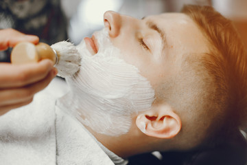 A man in a barbershop. Clipping beard in the barber. Rest in hairdressing salon