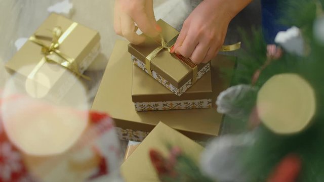 Christmas gifts concept. Female hands wrap Christmas presents. 4k, top view