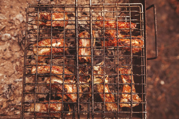 Frying meat over grill grid. Barbecue and cooking on the nature