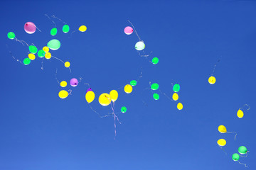 many multicolored balloons flying in the blue sky