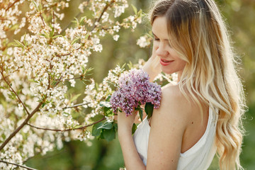 Fototapeta premium Beautiful girl in a white dress. Woman in a spring blooming park