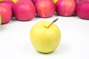 Yellow Apple on a background of red apples on white background