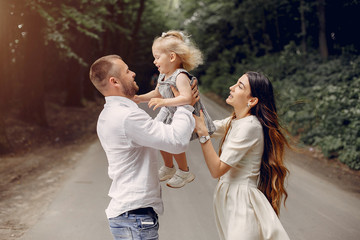 Family in a summer park. Mother and little daughter playing. Cute little girl with a father