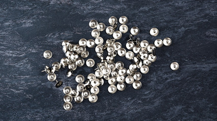 Scattered push pin on black background.