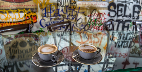 Two cups of cappuccino with latte art and colorful background
