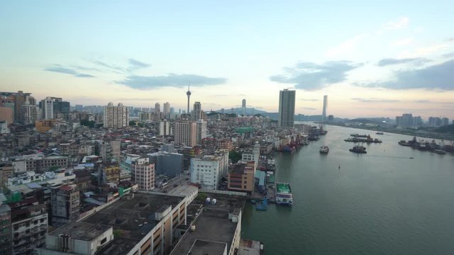 Daytime long shot of thriving city of Macau with densely packed buildings. Pan right.