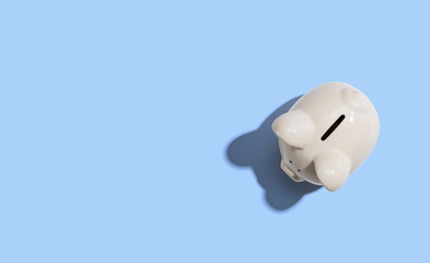 A white piggy bank overhead view flat lay