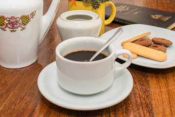 Pure coffee with cookies, bible and flowers in detail