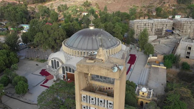 Rotating drone shot flying around bell tower with cross and Ethiopian Orthodox church in Aksum, Christian religion and culture in Ethiopia Africa